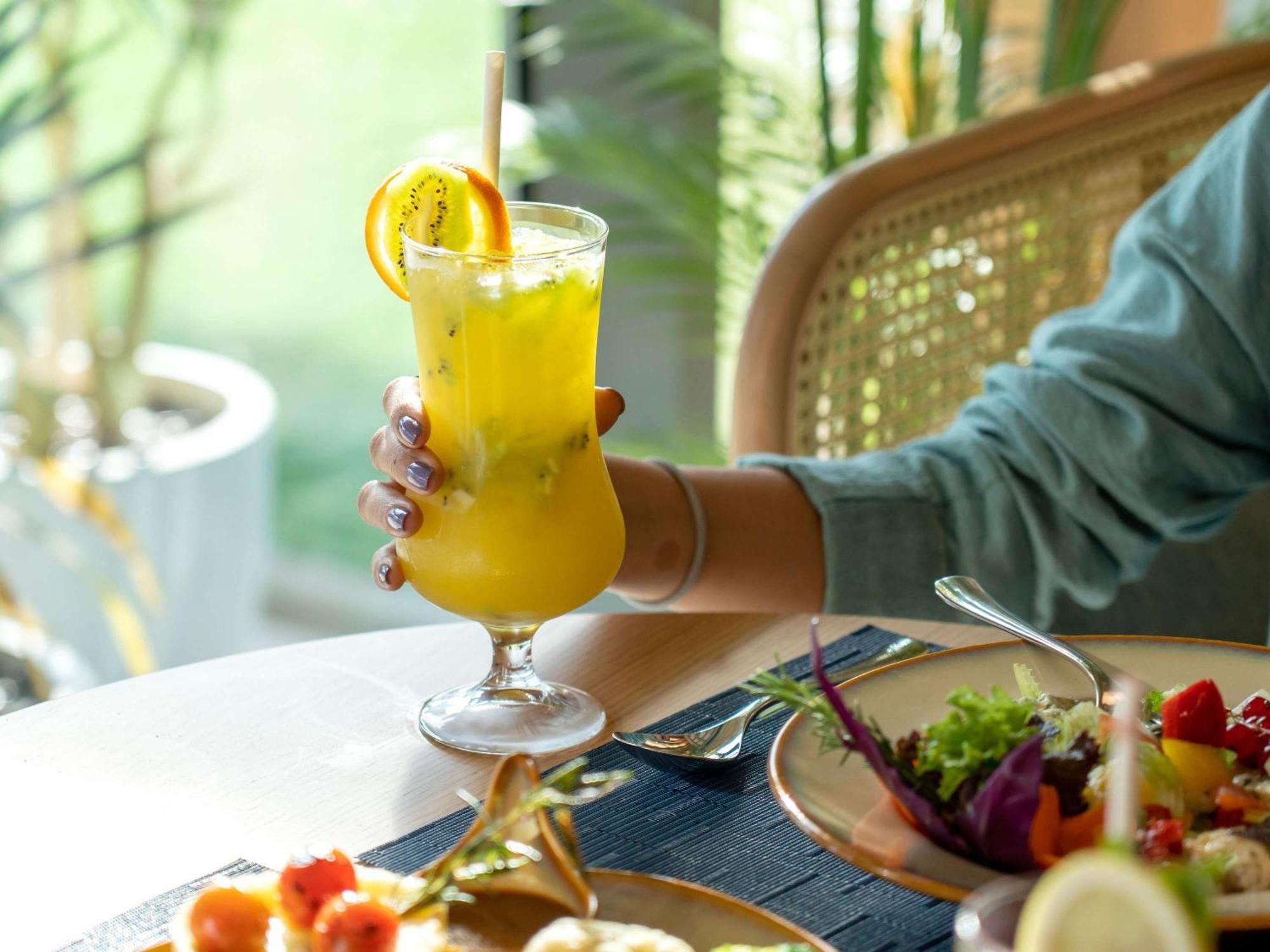 Swissotel Living جدة المظهر الخارجي الصورة A woman holding a glass of juice